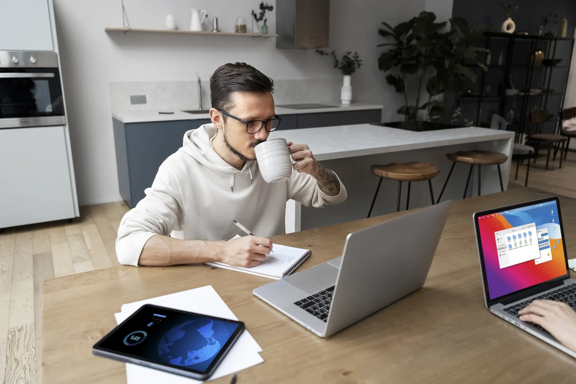 Business professional working across a laptop, tablet and phone while reviewing CRM follow-up for the article How Clean CRM Systems Improve Revenue Follow-Up.