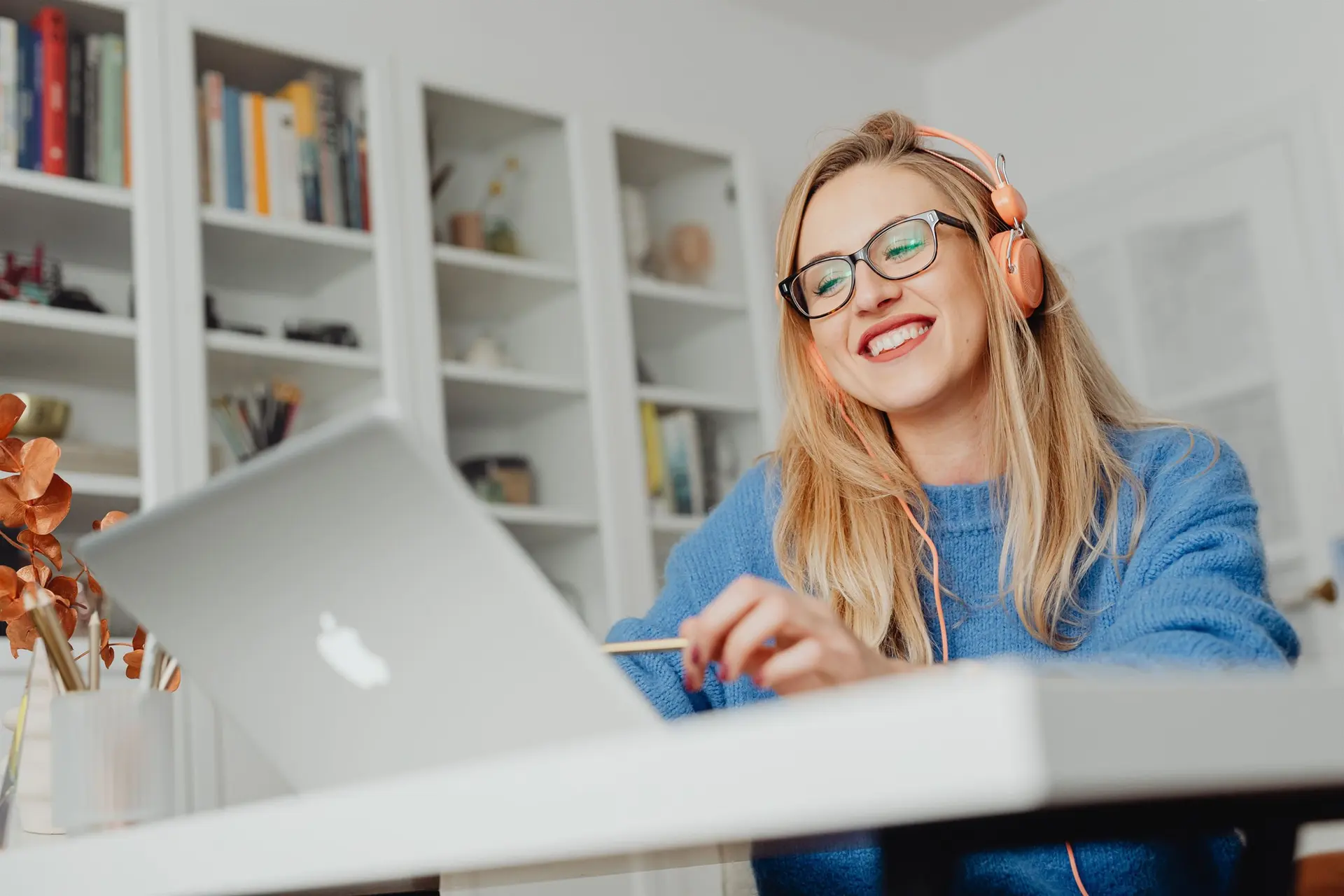 Administrative support professional using a headset and laptop to organize documents, follow-up tasks and digital workflows.