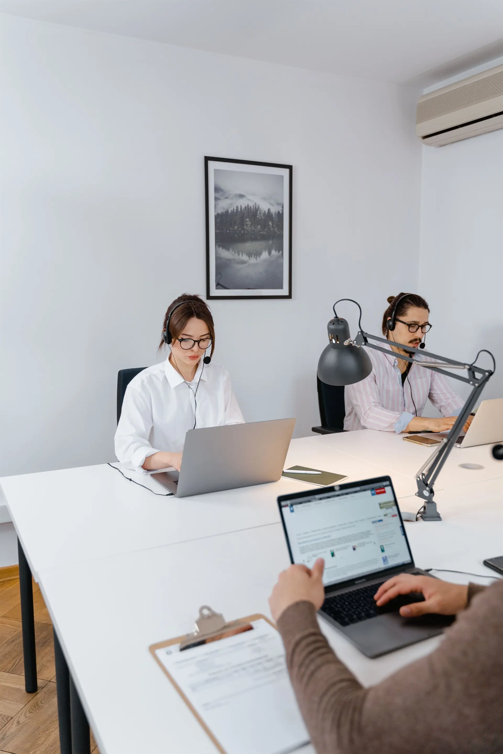 Business operations support team working at laptops to coordinate workflows, client communication and recurring priorities.